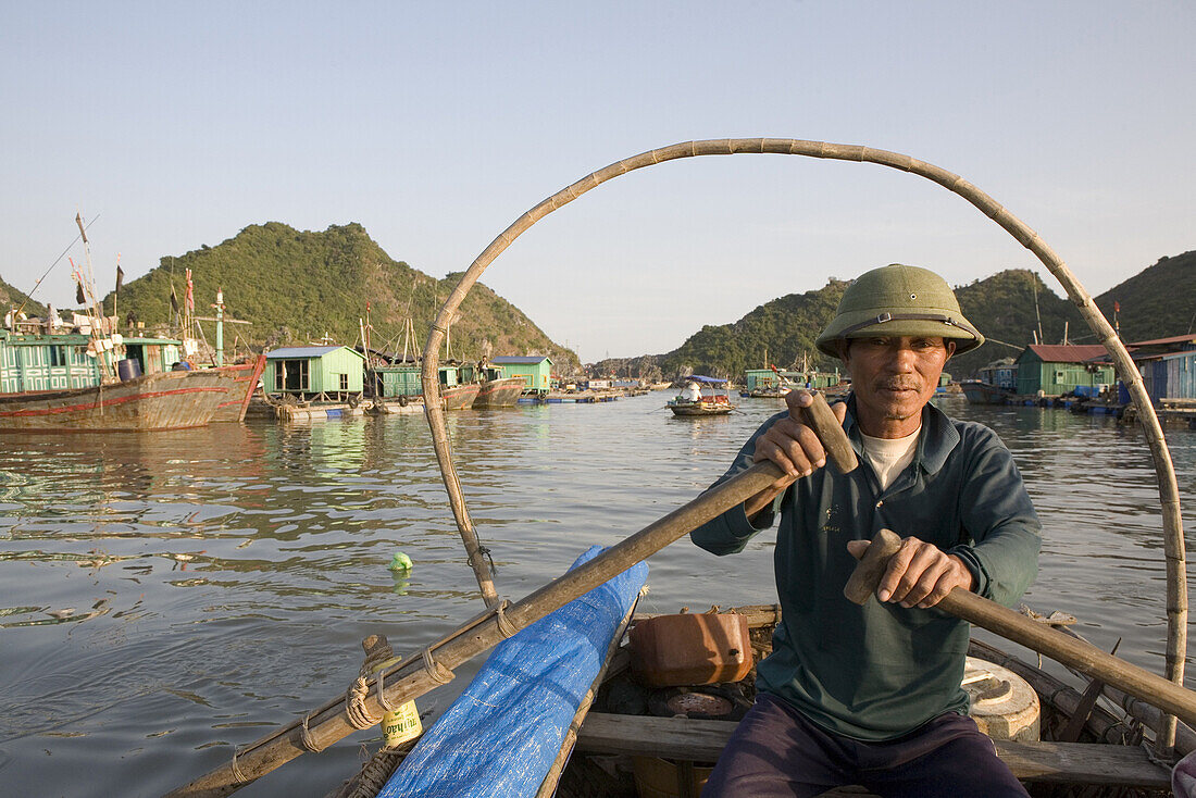 Fisherman at floating fishing village at the Halong Bay at the Gulf of Tonkin, Vietnam, Asia