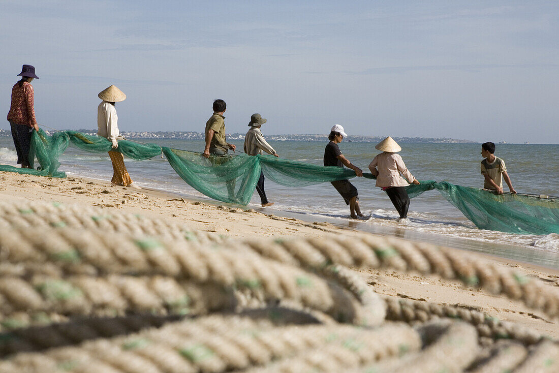 Fischer mit Fischernetz am Strand von Mui Ne, Provinz Binh Thuan, Vietnam, Asien