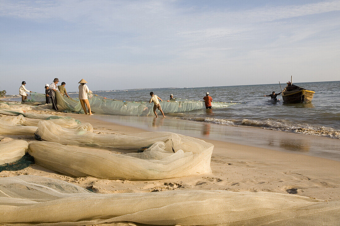 Fishermen with fishing net on the beach of Mui Ne, Binh Thuan Province, Vietnam, Asia