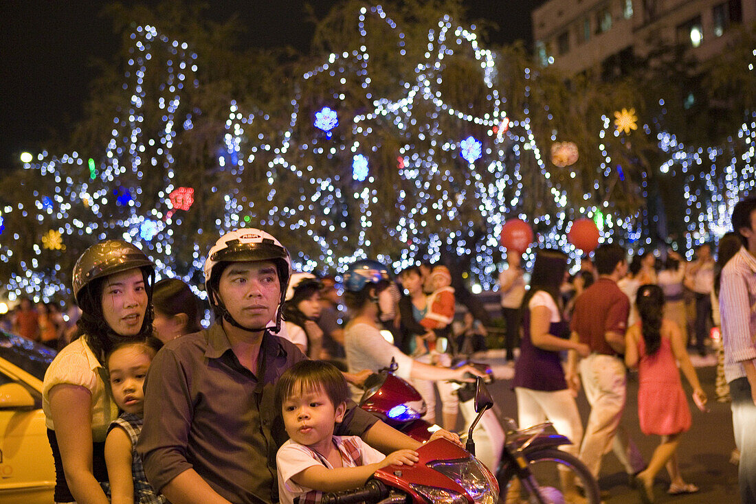 Junge vietnamesische Familie vor Weihnachtsdekoration im Zentrum von Saigon, Hoh Chi Minh City, Vietnam, Asien