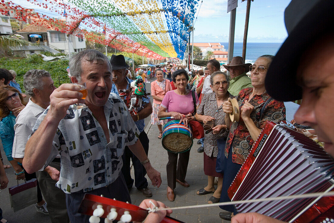 Man enjoying a glass of Madeira wine and listening to the Filarmonica Band playing at the religious festival, Ponta Delgada, Madeira, Portugal