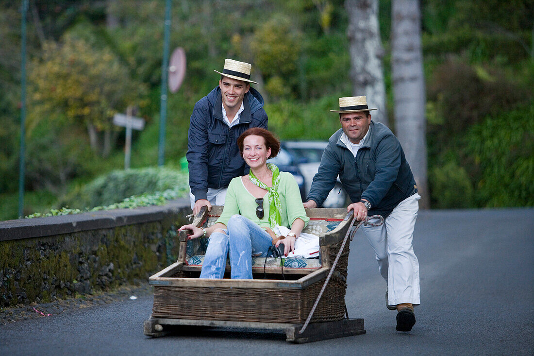Frau genießt Korbschlittenfahrt in Monte, Funchal, Madeira, Portugal