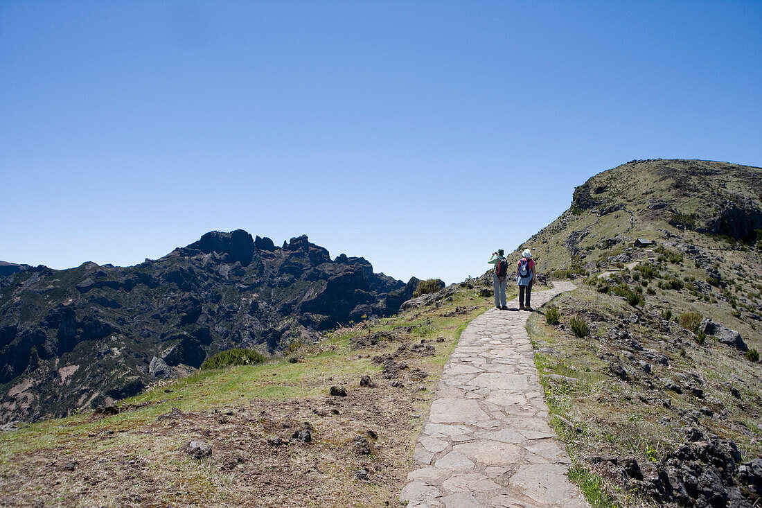 Two hikers on a trail to the Pico Ruivo Summit, Achada do Teixeira, Madeira, Portugal