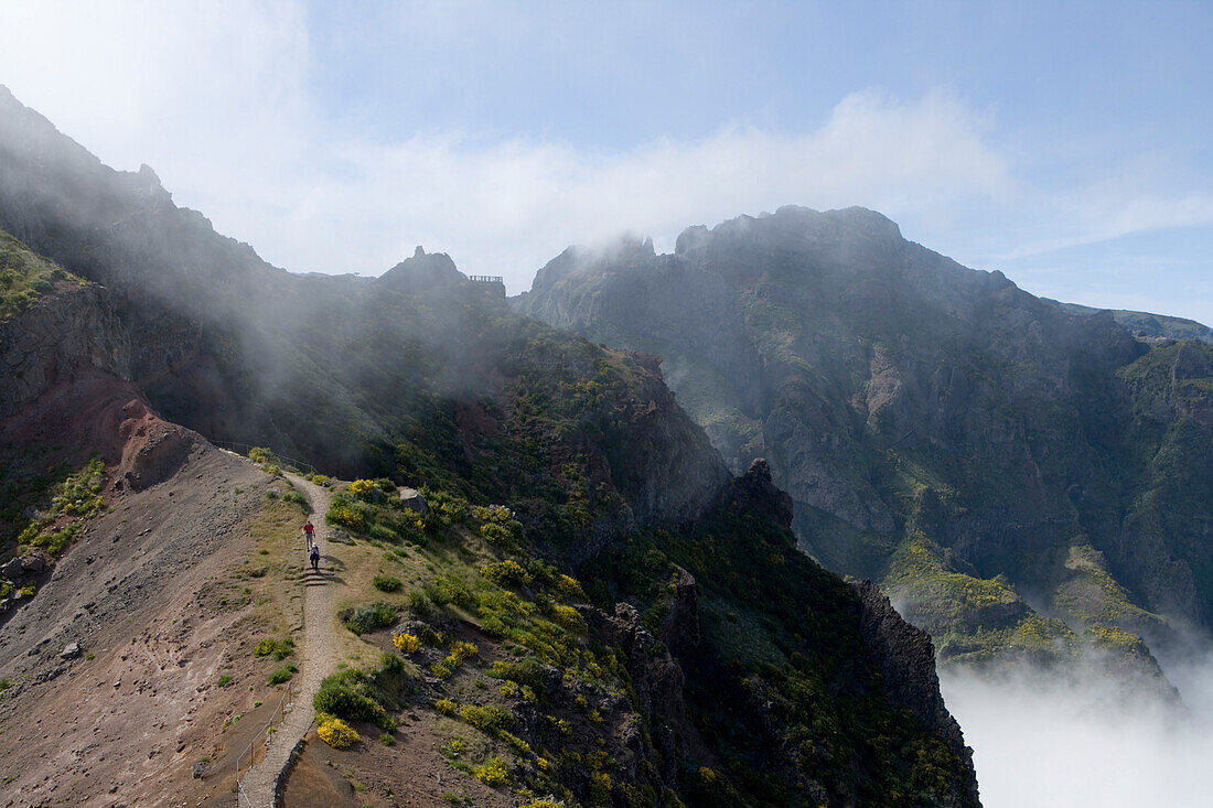 Hikers on a hiking path between Pico do Arieiro and Pico Ruivo Mountains, Pico do Arieiro, Madeira, Portugal