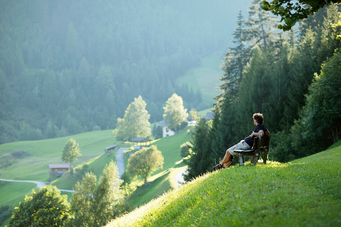 Mann sitzt auf einer Bank, Pflerschtal, Südtirol, Trentino-Alto Adige, Italien