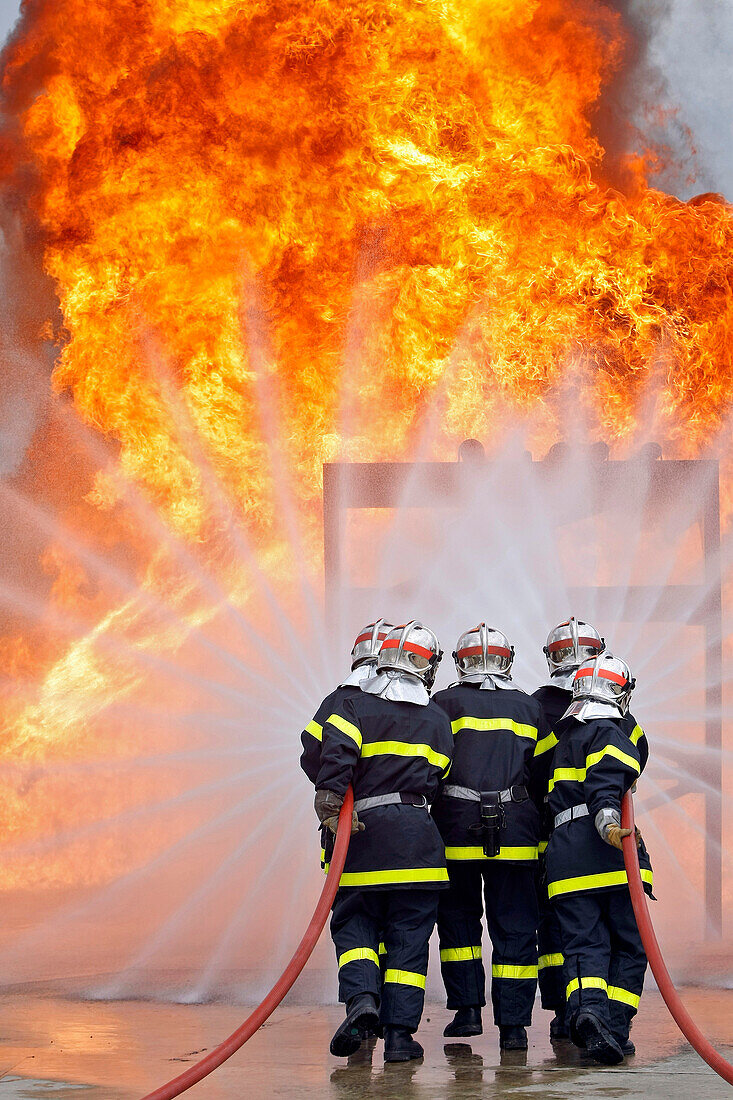 Firefighters Approaching A Fire. Training Of The Firefighters Of The Sdis38 In Hydrocarbon Fires, Gesip (Study Group Of Safety In The Petrol And Chemical Industries) Of Roussillon, Isere (38), France