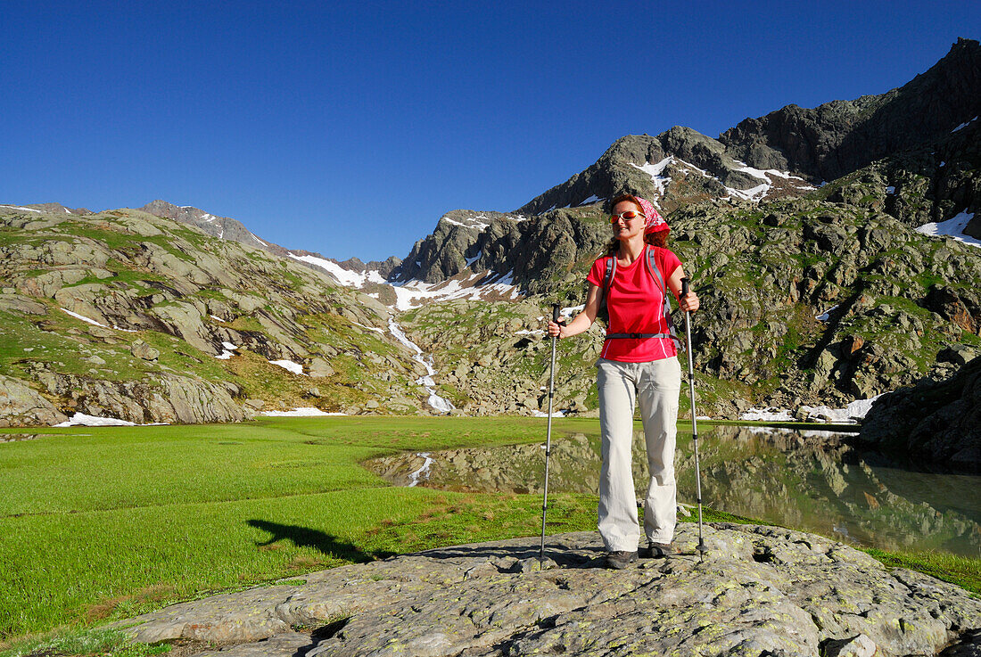 Woman hiking along lake Stubensee, Stubai Alps, Trentino-Alto Adige/South Tyrol, Italy
