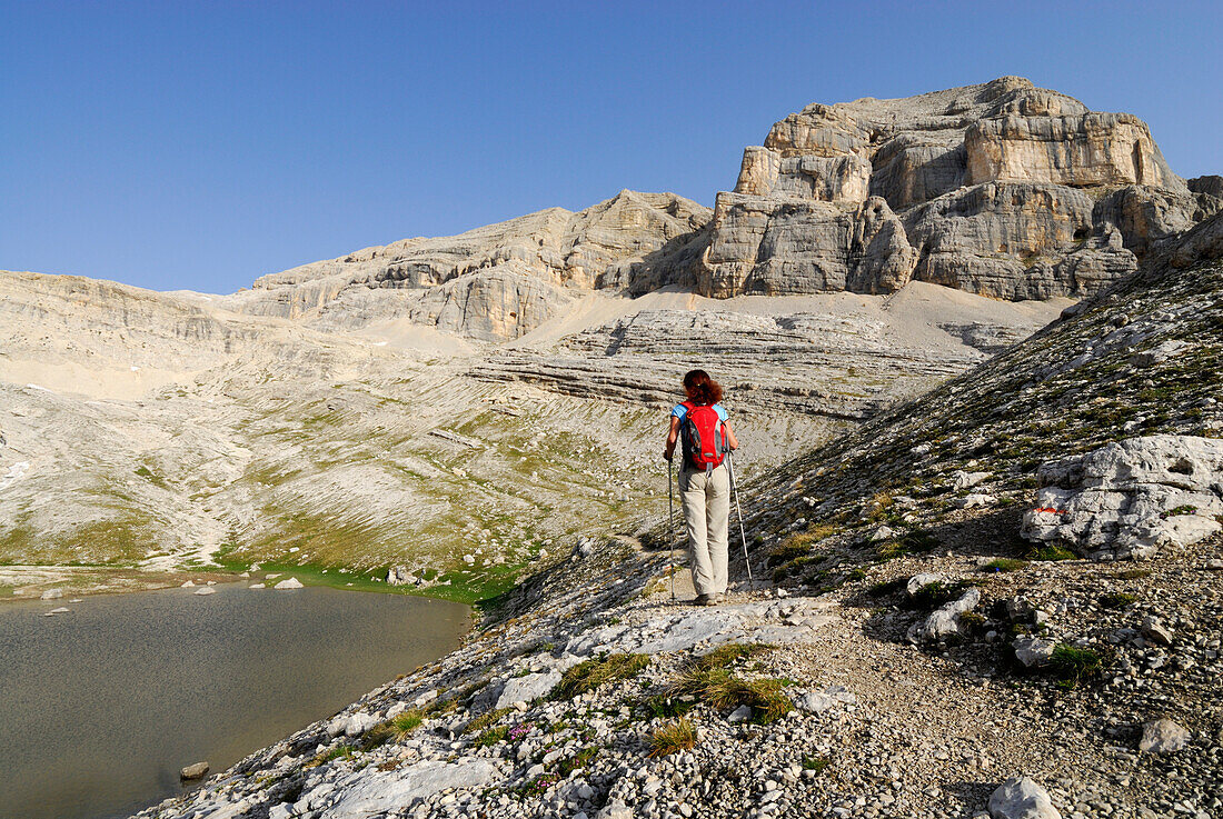 Woman hiking along lake Conturines, La Varella, Naturpark Fanes-Sennes-Prags, Dolomites, Trentino-Alto Adige/South Tyrol, Italy