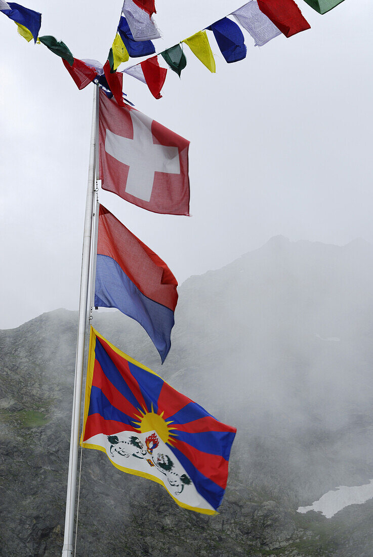 Fahnenmast mit Gebetsfahnen und Flaggen, Tessiner Alpen, Tessin, Schweiz