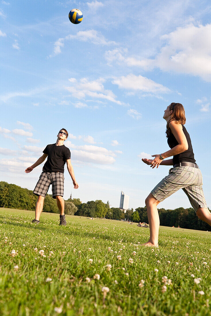 Young people playing volleyball on a meadow, Leipzig, Saxony, Germany