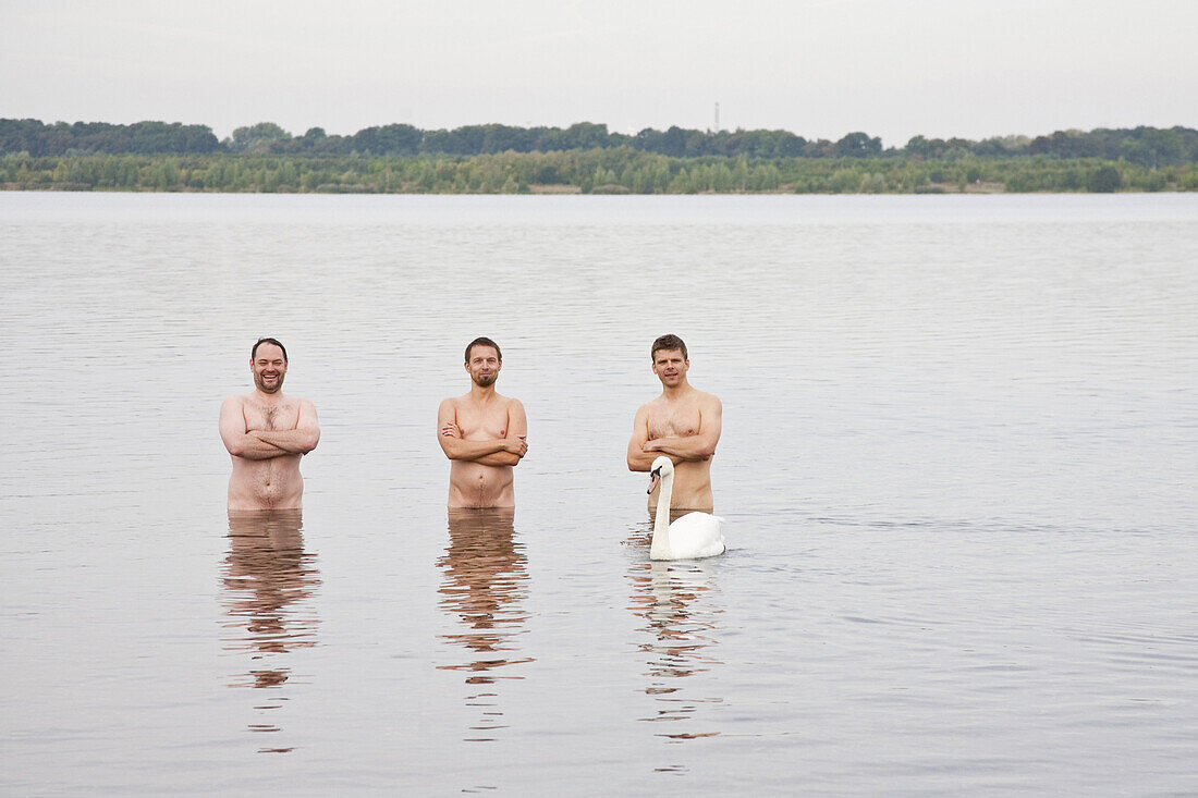 Drei Männer stehen nackt im Cospudener See, Leipzig, Sachsen, Deutschland