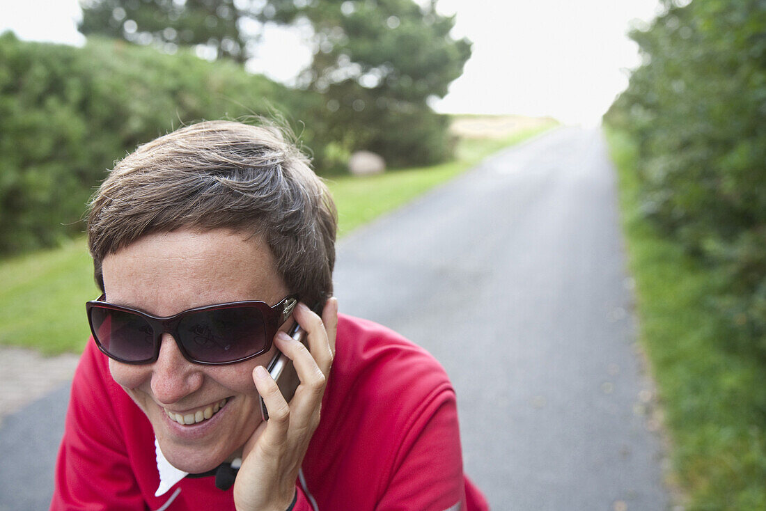 Woman phoning with a mobile phone, Utersum, Foehr island, Schleswig-Holstein, Germany