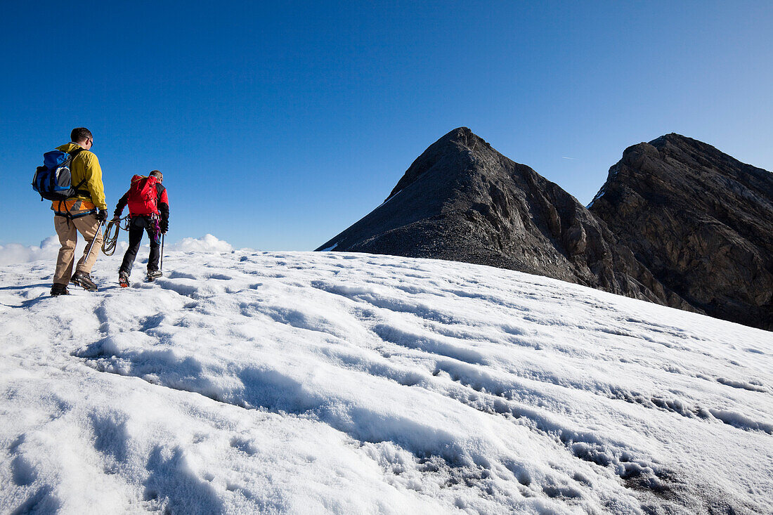 Two men hiking on Huefifirn, Clariden in background, Canton of Uri, Switzerland