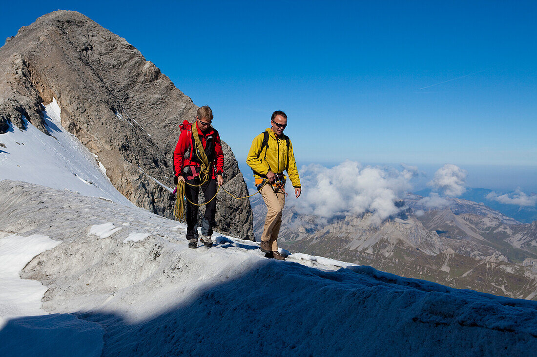 Zwei Bergsteiger laufen über Eisgrat zum Gipfel, Clariden, Kanton Uri, Schweiz