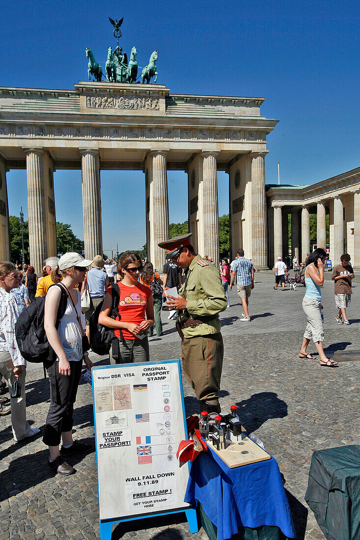 Man Dressed As A Soldier Of The Ex-Ddr Letting Tourists Take His Photo And Selling Ddr Visa Stamps, Brandenburg Gate, Brandenburger Tor On The Pariser Platz. Berlin, Germany