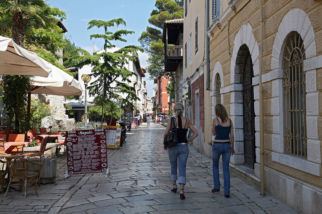 Young Teenagers, Tourists In The Street Near The Port In The Town Of Porec, Istria, Croatia