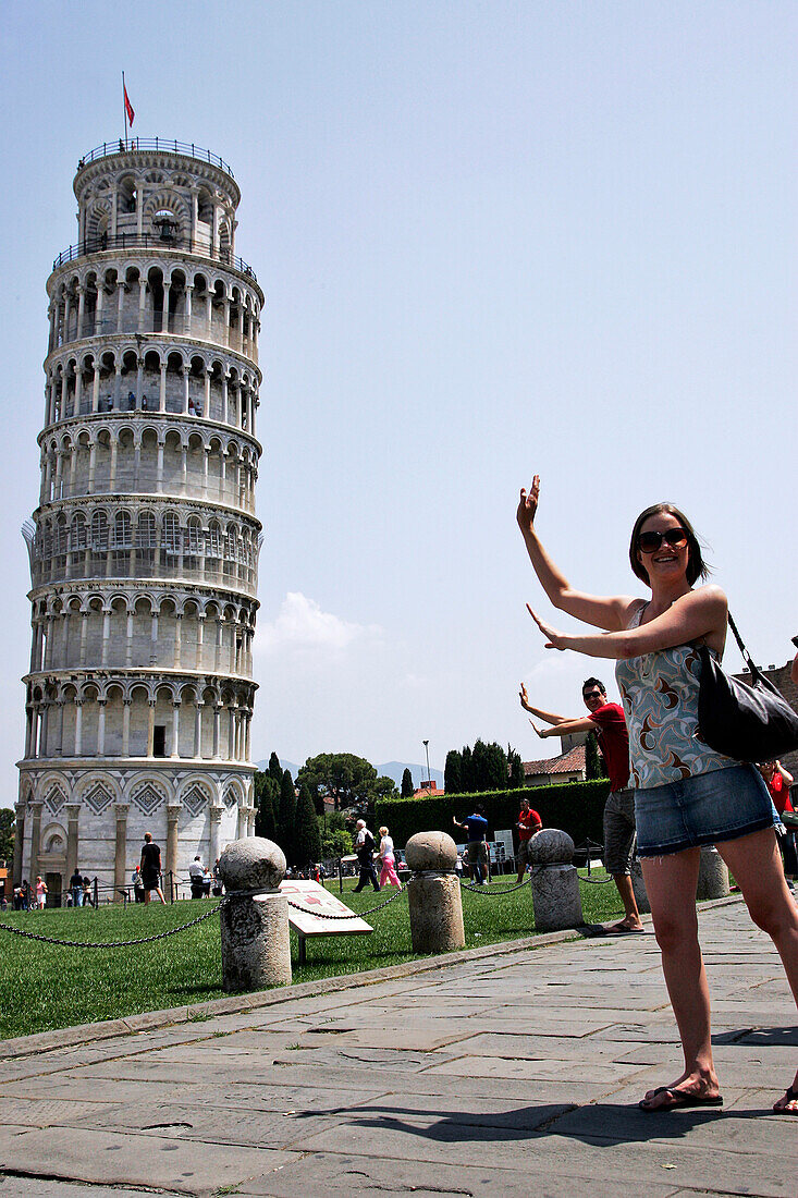 Tourists Having Themselves Photographed In Front Of The Leaning Tower (Torre Pendente), Baptistery And Cathedral (Duomo) On The Campo Dei Miracoli, Pisa, Tuscany, Italy