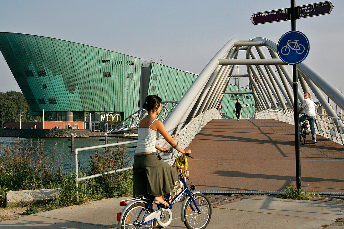 Bike Ride By The Science Center 'Nemo', Similar To A Green Vessel, A Work By The Architect Renzo Piano, Amsterdam, Netherlands