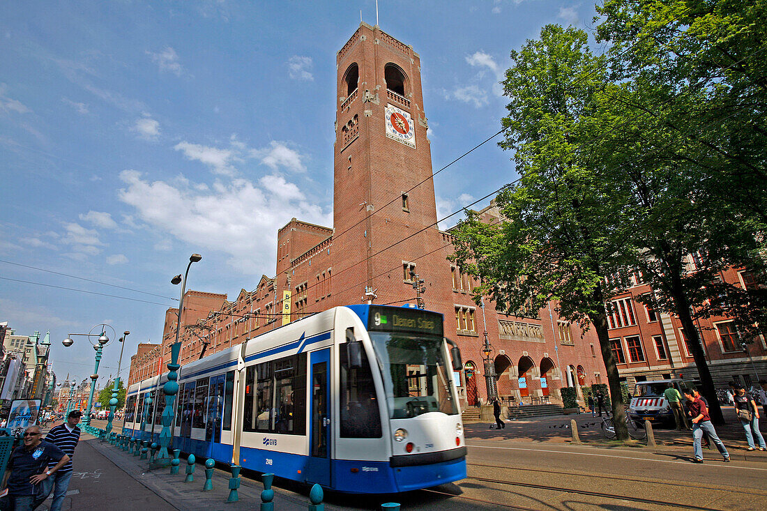 Tramway On Damrak Street And Beurs Van Berlage Designed By H. P. Berlage, Very Imposing With Its 141 Meters Of Red Brick Facade Along The Damrak. Seat Of The Netherlands Philharmonic Orchestra, The Big Hall With Perfect Acoustics Hosts Concerts And Other 