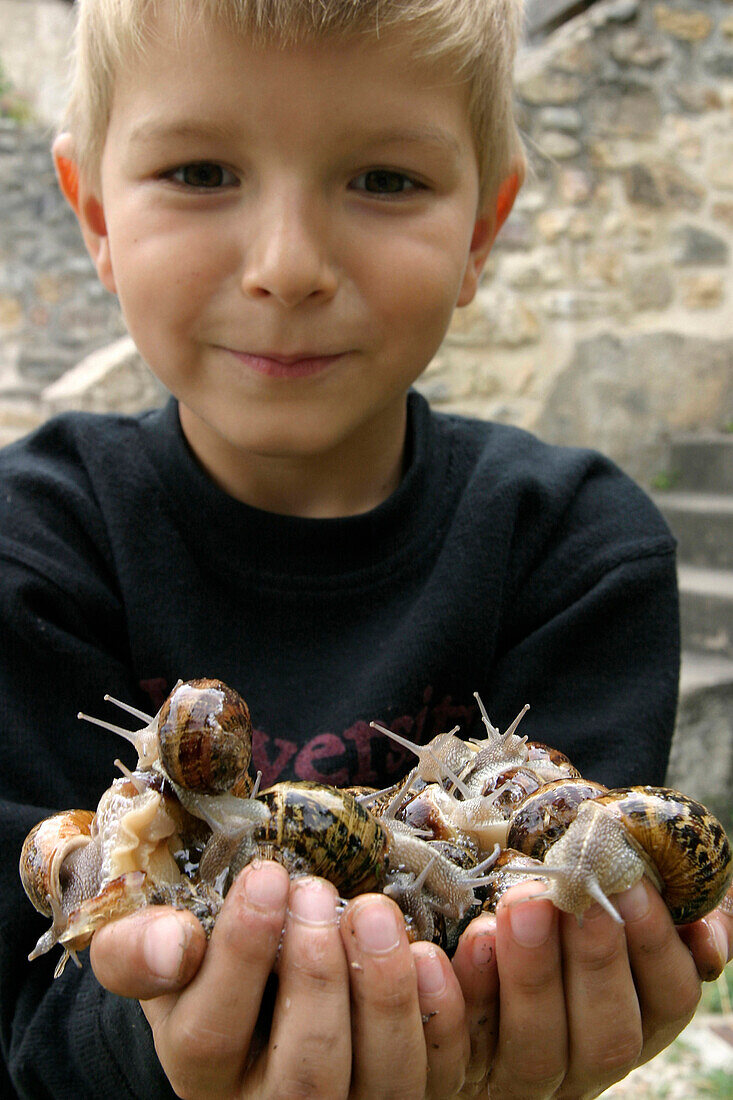 Child With A Handful Of Snails, France