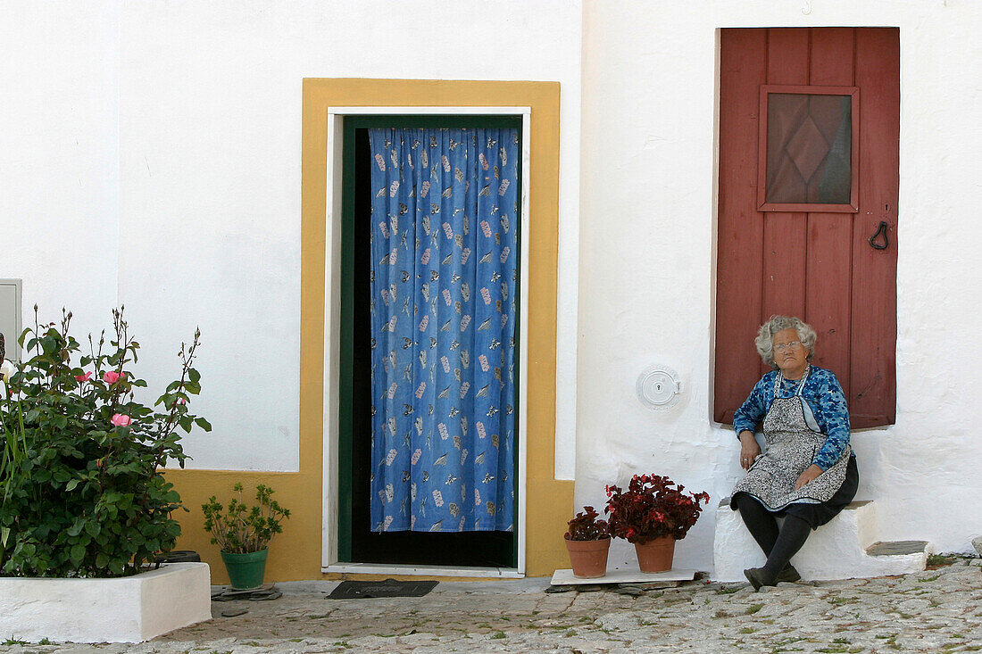 Portuguese Woman At The Foot Of The Entrance To Her House, Village Of Terena, Alentejo, Portugal