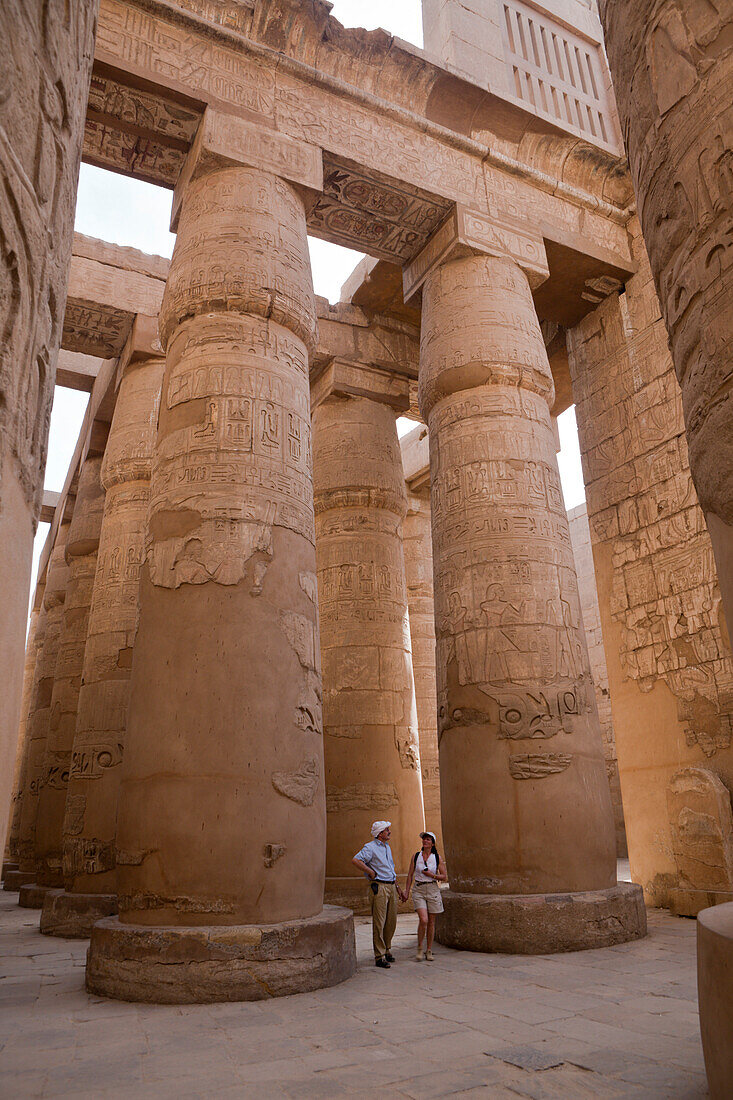 Tourists between Pillars of Great Hypostyle Hall at Karnak Temple, Luxor, Egypt