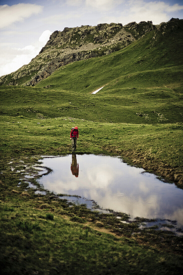 Hiker at lake, Raetikon Hoehenweg Nord, Montafon, Vorarlberg, Austria