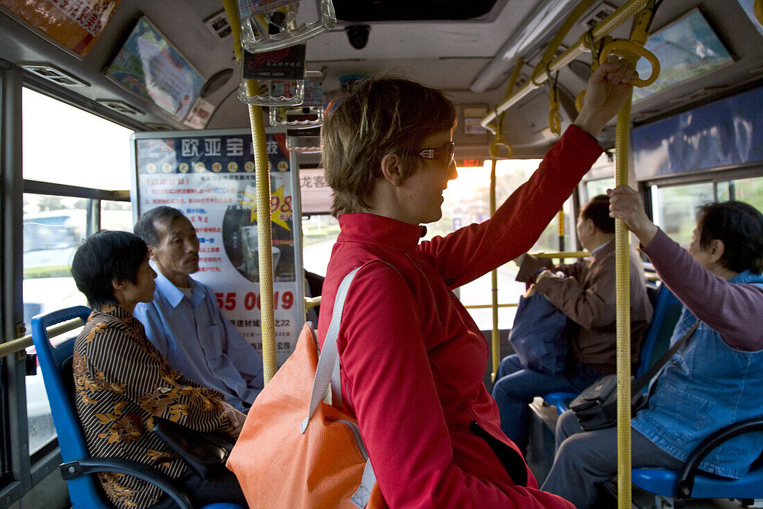 Deutsche Touristin im Bus bei Sonnenuntergang, Xiamen, Fujian Provinz, China, Asien