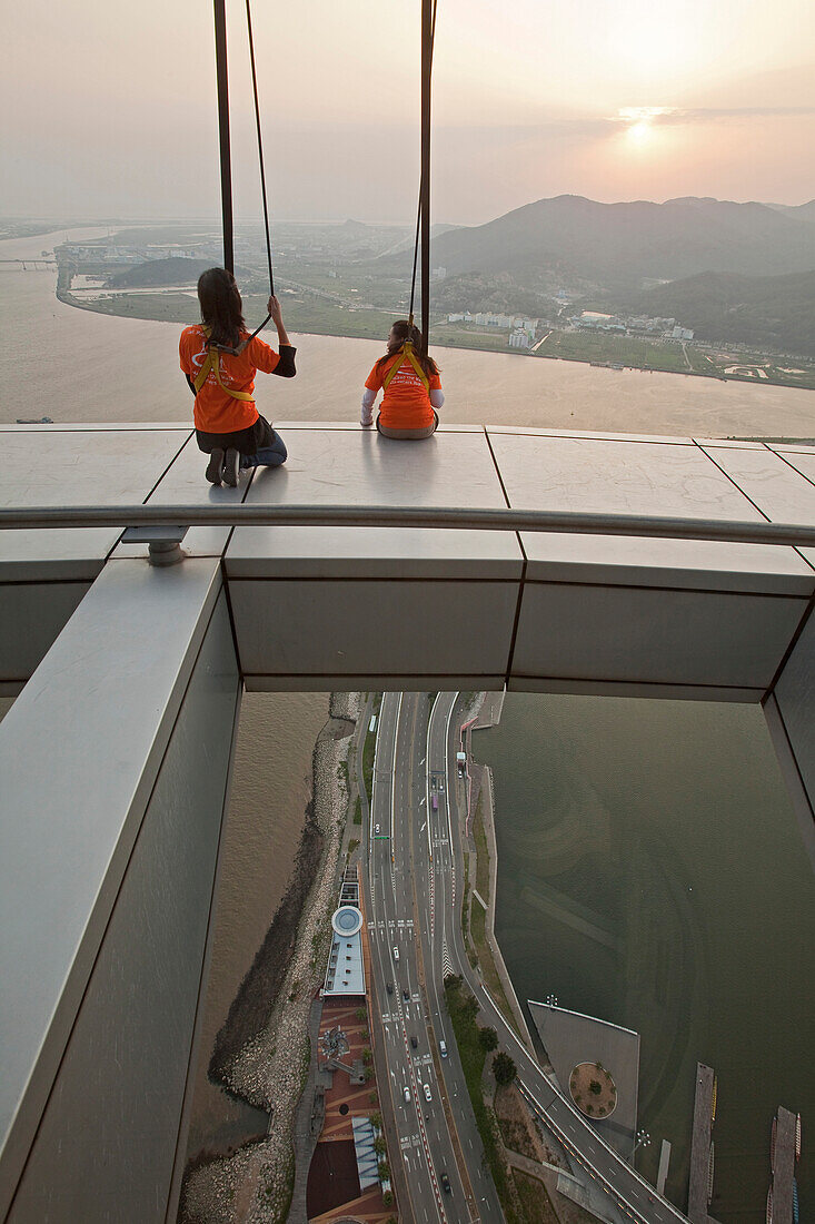 Menschen an Seilen auf der Aussichtsplattform des Macao Turms bei Sonnenuntergang, Macao, China, Asien