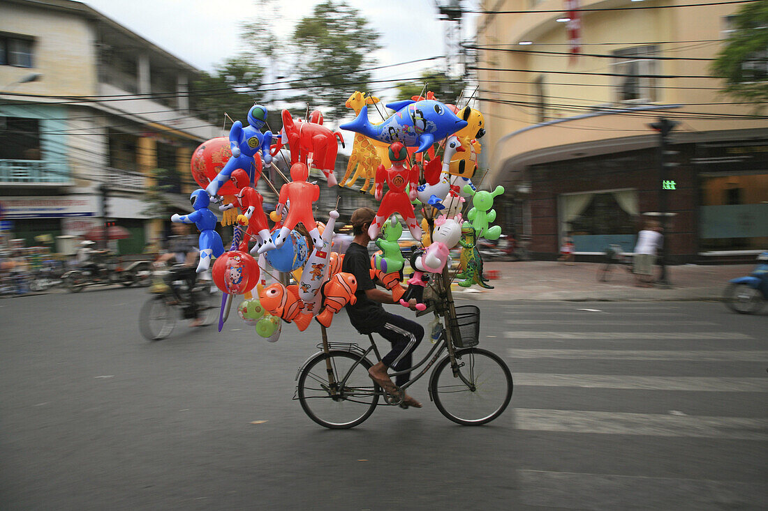 Balloon vendor on a bike during Tet festival, Saigon, Ho Chi Minh City, Vietnam, Asia