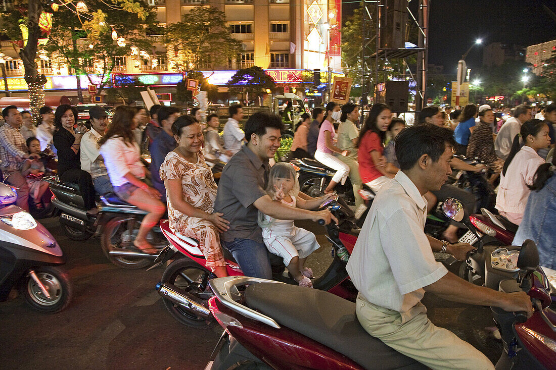 Menschen fahren auf Motorrollern während des Tet Fests bei Nacht, Saigon, Ho Chi Minh Stadt, Vietnam, Asien