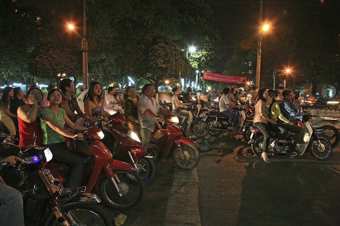 Menschen fahren auf Motorrollern während des Tet Fests bei Nacht, Saigon, Ho Chi Minh Stadt, Vietnam, Asien