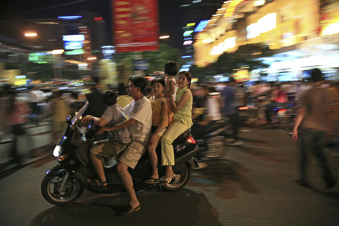 Familie mit Kindern auf Motorroller während des Tet Fests bei Nacht, Saigon, Ho Chi Minh Stadt, Vietnam, Asien