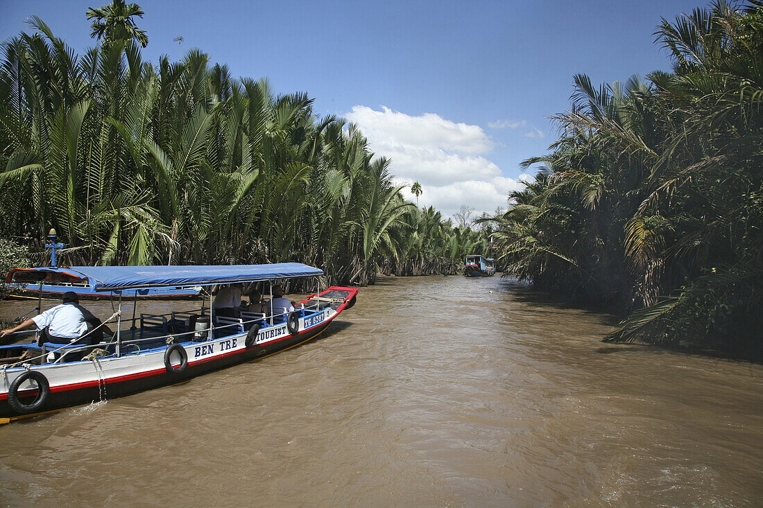 Excursion boat with tourists on a canal, Mekong Delta, Vietnam, Asia