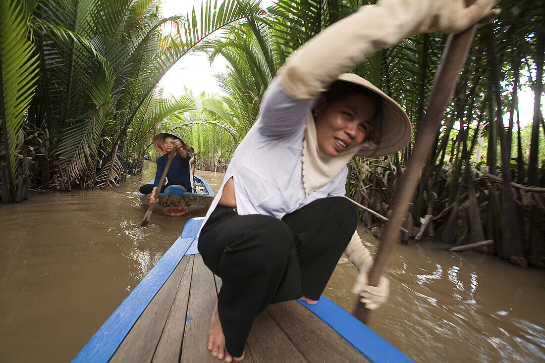 Frau mit Paddel in einem Boot auf einem Kanal, Mekong Delta, Vietnam, Asien