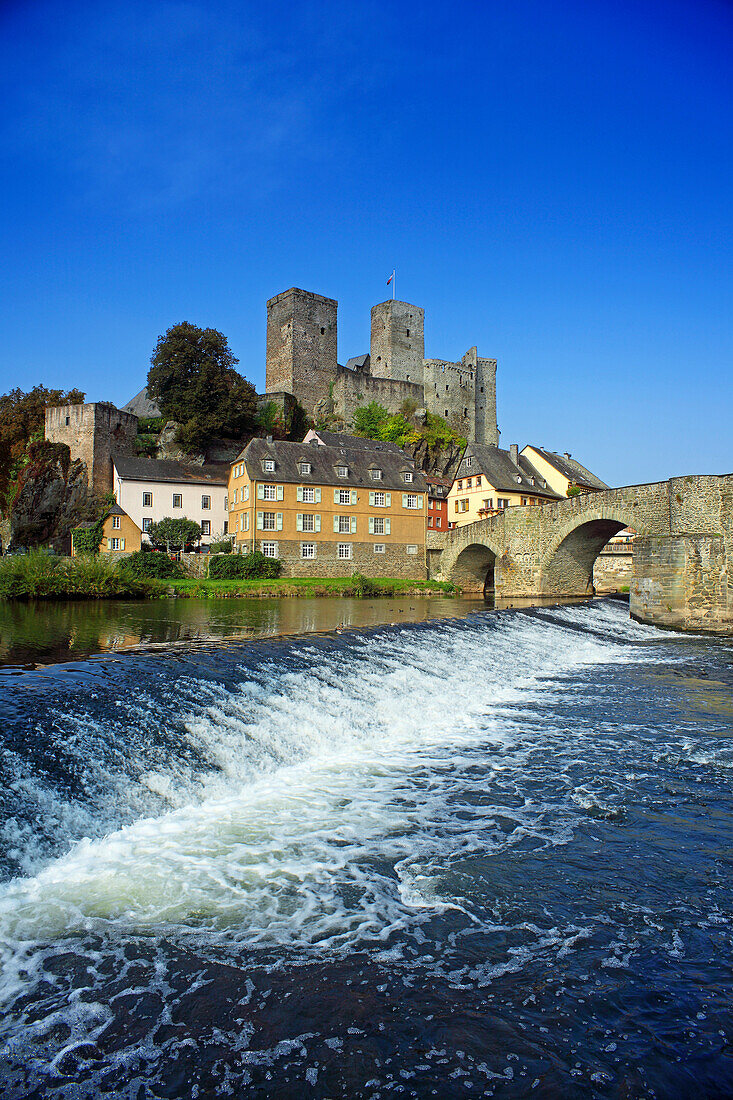 View over Lahn river with stone bridge to castle ruin, Runkel, Hesse, Germany