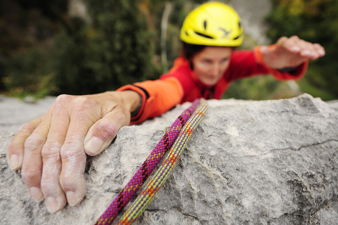 Woman climbing on rock face, Torbole-Nago, Lake Garda, Trentino-Alto Adige/South Tyrol, Italy