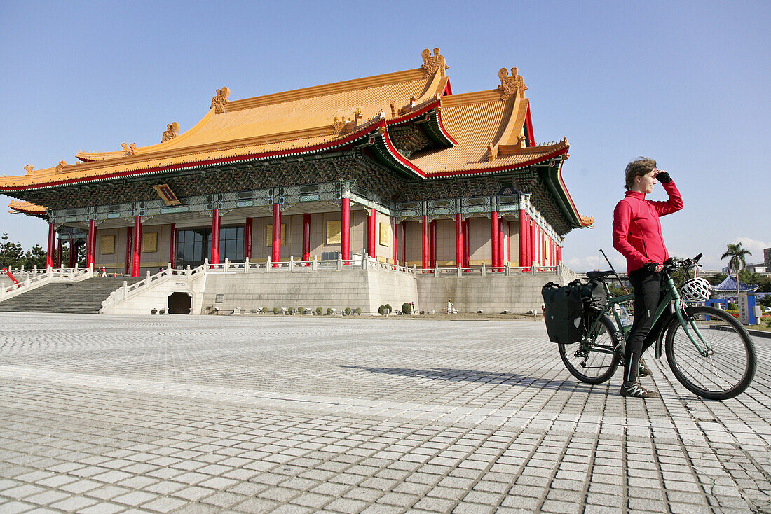 Young German woman on bicycle in front of National Theatre and National Concert Hall, Taipei, Republic of China, Taiwan, Asia