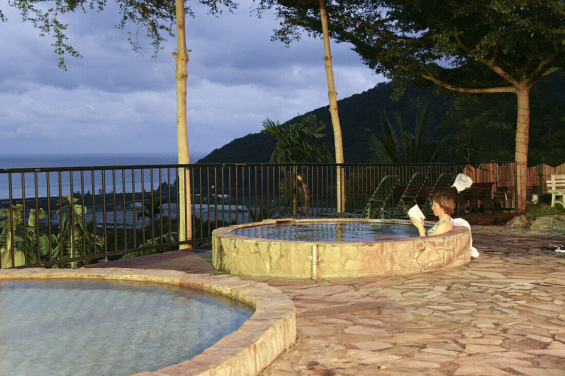 Woman reading a book in pool of hot springs, East Sun Spa Spring Hotel, Jinluan Hot Springs, Jinluan, Republic of China, Taiwan, Asia