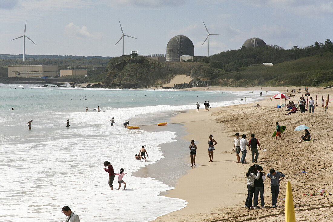 People on the beach in front of wind wheels and nuclear power plant Nanwan, Kenting, Republic of China, Taiwan, Asia
