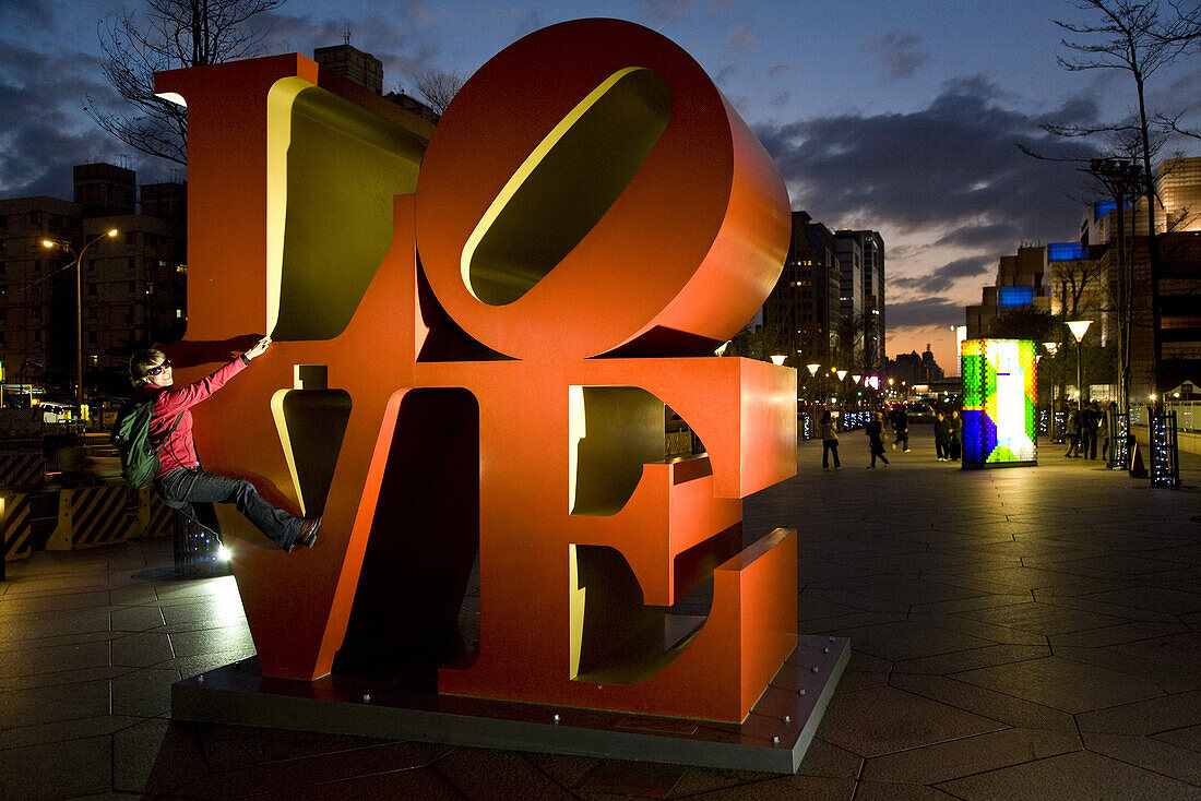 LOVE Kunstinstallation vor dem Hochhaus Taipei 101, junge deutsche Frau klettert an grossen Buchstaben, Taipeh, Republik China, Taiwan, Asien