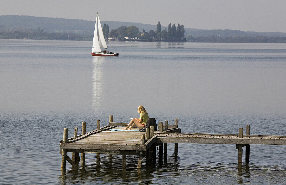 Woman on a jetty at lake Steinhude, Lower Saxony, Germany