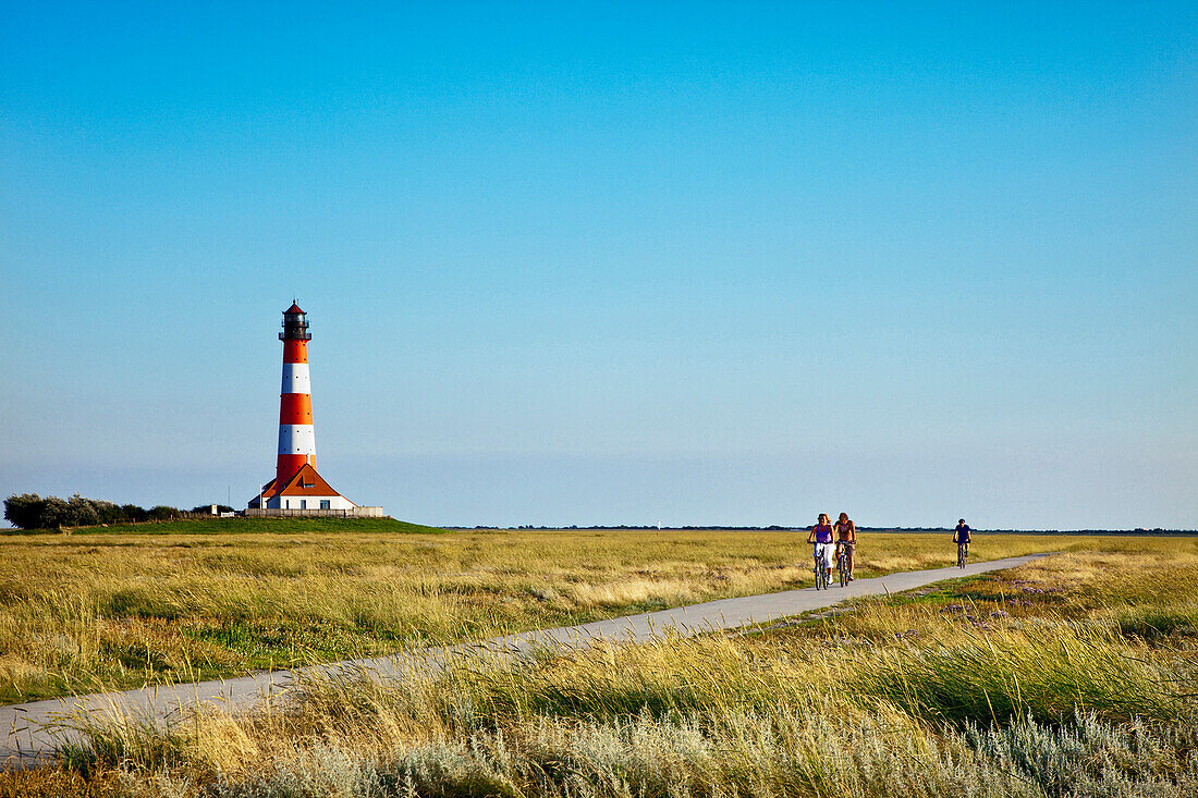 Cyclists near Westerheversand Lighthouse, Westerhever, Schleswig-Holstein, Germany