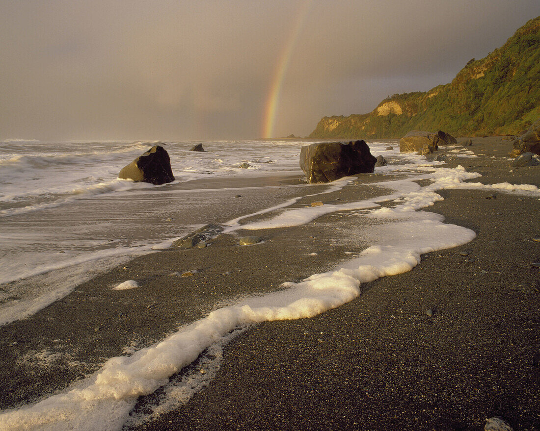 Sunset and rainbow after westerly storm Okarito Beach Westland New Zealand