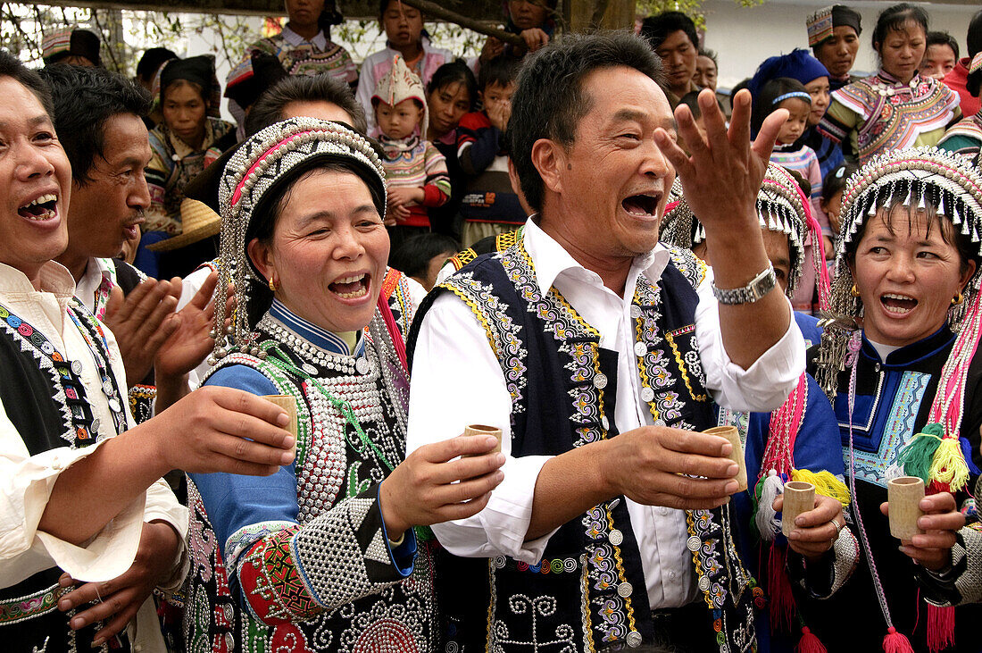 Hani Akha women and men singing a toast at the Long Table Festival in Yuanyang China