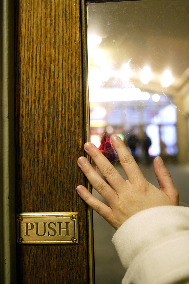 Hand of a woman pushing a door open at Grand Central Terminal railway station,  Manhattan,  New York City,  United States,  North America