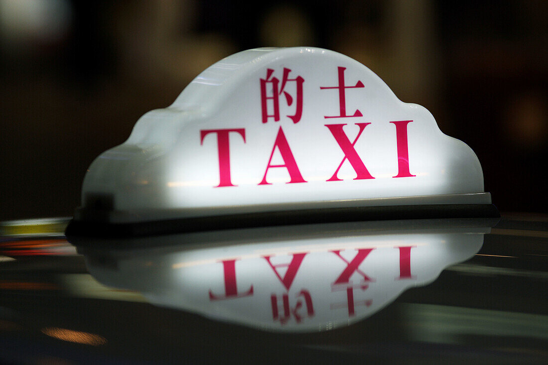 Close up of a taxi sign in chinese and latin letters on the roof of taxis,  standing in a row in the amusement center of Wanchai,  Hong Kong Island,  Hong Kong,  China,  East Asia
