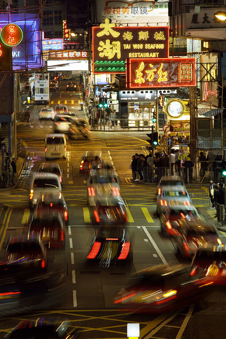 Busy street at night with cars moving along the street and colorful neon advertisements in chinese letters at Causeway Bay,  Hong Kong Island,  Hong Kong,  China,  Southeast Asia