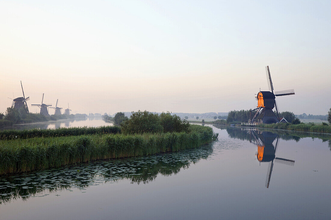 Wind mills next to irrigation canal,  Holland