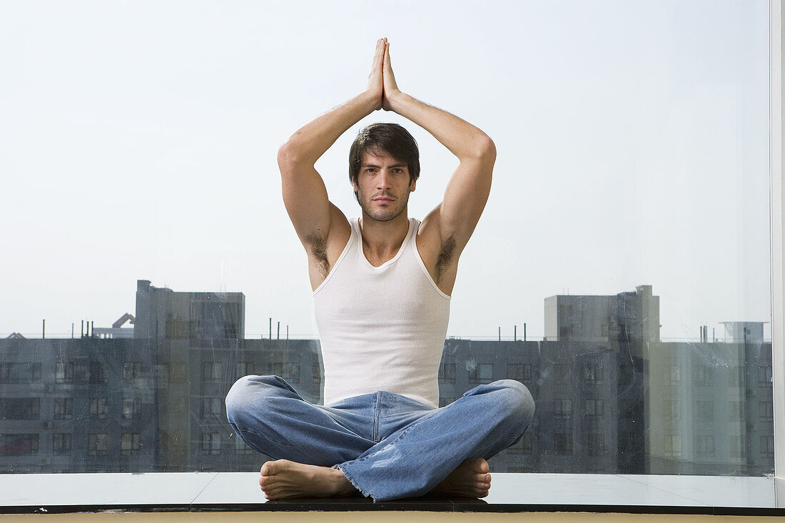 Man sitting in yoga position on floor